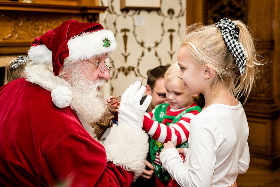 Santa talks to two children.